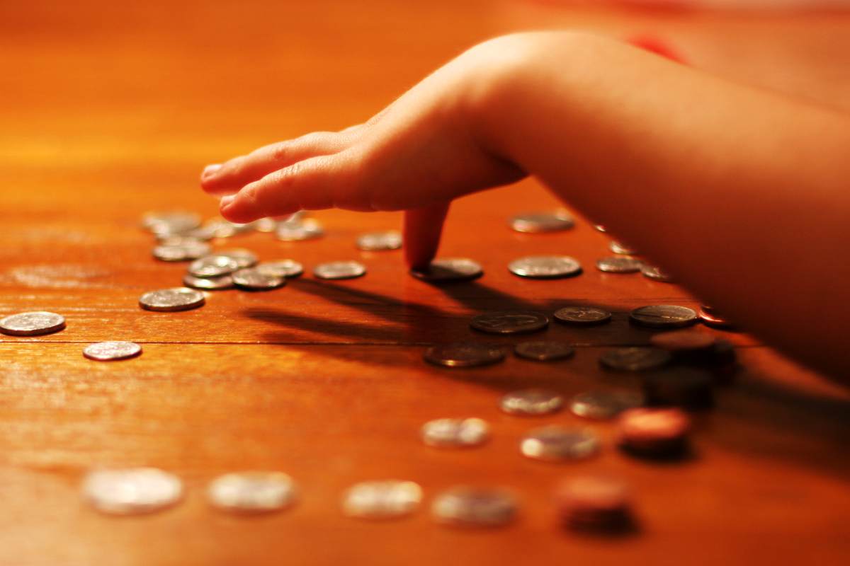 mano di bebè su monete